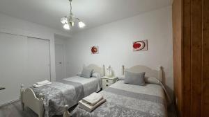 two beds in a room with white walls at CASA DEL VIDRIO in Castril +44 photos