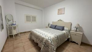 a bedroom with a bed and a table with a mirror at CASA DEL VIDRIO in Castril