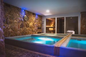 a hot tub in a room with a stone wall at Inghirios Wellness Country Resort in Santa Maria la Palma +48 photos