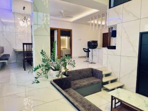 a living room with a couch and some plants at E7 Apartment in Bekal
