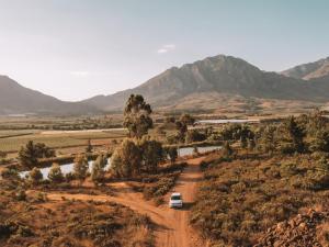 a van parked on a dirt road with mountains in the background at Barn Owl Cabin at Vrolikheid Landgoed in Tulbagh