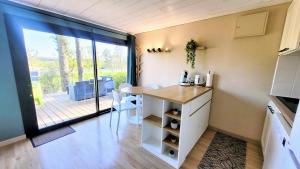a small kitchen with a table and a balcony at LE COTTAGE VUE LAC-2 vélos-Village Vacances Nature de 70ha! avec piscines et animations in Léon