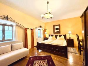 a bedroom with a large bed and a couch at Gästehaus Turm Wachau in Weissenkirchen in der Wachau