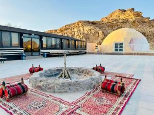 un edificio con una fuente frente a una montaña en Desert calm, en Wadi Rum