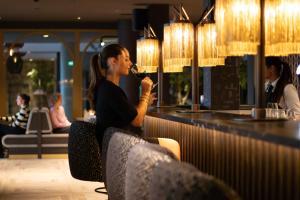 uma mulher sentada num bar a beber um copo de vinho em Van der Valk Hotel Vianen - Utrecht em Vianen