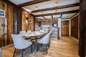 een eetkamer met een tafel en stoelen bij Luxury suite 70m2 balcon courchevel1850 parking in Courchevel