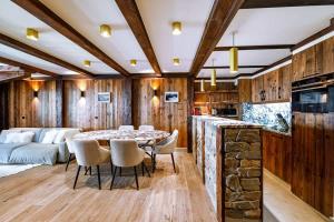 een keuken en woonkamer met een tafel en stoelen bij Luxury suite 70m2 balcon courchevel1850 parking in Courchevel