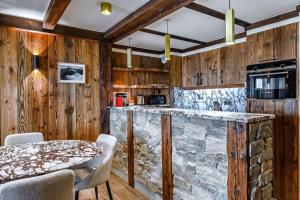 een keuken met een stenen aanrecht en een tafel bij Luxury suite 70m2 balcon courchevel1850 parking in Courchevel