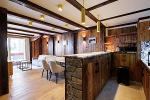een keuken met een stenen aanrechtblad en een woonkamer bij Luxury suite 70m2 balcon courchevel1850 parking in Courchevel