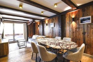een eetkamer met een tafel en stoelen bij Luxury suite 70m2 balcon courchevel1850 parking in Courchevel +23 foto's