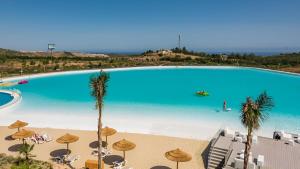 a large swimming pool with chairs and umbrellas at La Casa Colores in Casares