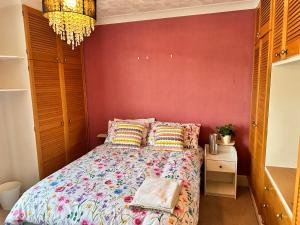 a bedroom with a bed and a red wall at Private Rooms in Portsmouth in Portsmouth