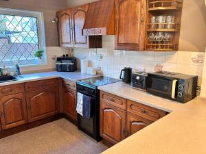 a kitchen with wooden cabinets and a black microwave at Private Rooms in Portsmouth in Portsmouth +9 photos