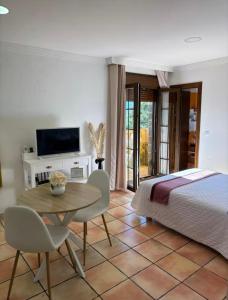 una camera da letto con un letto, un tavolo e delle sedie di La Posada RR junto al Aeropuerto de Málaga a Málaga