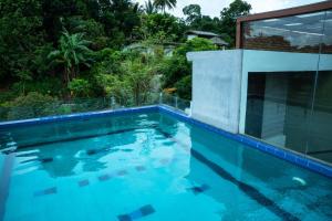 a swimming pool in front of a house at Riverside Lounge Kandy in Sirimalwatta