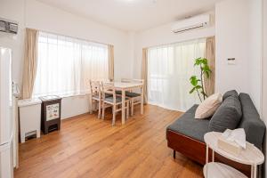 una sala de estar con un sofá y una mesa en U Stay 西川口, en Kawaguchi