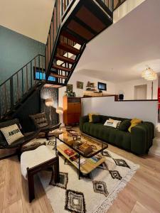a living room with a green couch and a staircase at Gîtes et Spa en Normandie in Sainte-Marguerite-de-Viette +101 photos