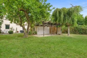 a house with a tree in a yard at Moderne Traumwohnung mit Traumgarten in Mayen