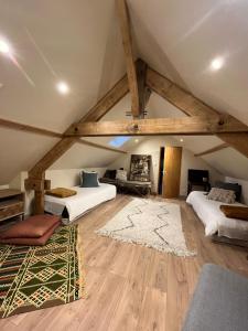 a attic room with two beds and a rug at Gîtes et Spa en Normandie in Sainte-Marguerite-de-Viette