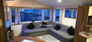 a living room with a couch and a table at Golden Gate Holiday Centre in Kinmel Bay