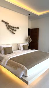 une chambre avec un grand lit dans une pièce dans l'établissement Villa JAYA Nyanyi, à Munggu 78 autres photos