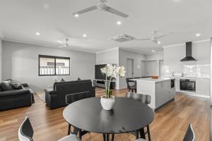 a living room with a table and a kitchen at Broome Villa Oasis in Broome +3 photos