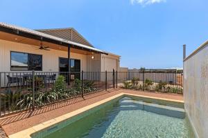 a swimming pool in front of a house at Broome Villa Oasis in Broome