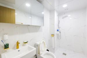 a white bathroom with a toilet and a shower at 온담펜션 