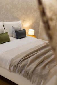 un lit blanc avec deux oreillers dessus dans l'établissement Maison Carola Sous Les Étoiles, à Aoste