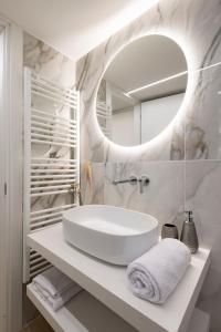 une salle de bain blanche avec un lavabo et un miroir dans l'établissement Maison Carola Sous Les Étoiles, à Aoste