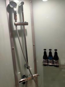 a bathroom with a mirror and three bottles of soda at HOTEL ERENOA - Vacation STAY 61067v in Nagoya +2 photos