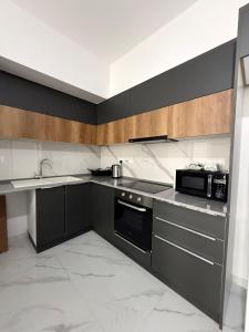 a kitchen with black cabinets and a sink and a microwave at Riverside Life Residence in Iskele