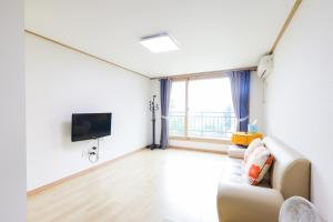 a living room with a couch and a tv at 온담펜션 