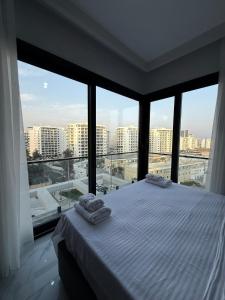 a bedroom with a bed with large windows at Riverside Life Residence in Iskele