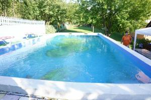 a large pool of water with a man standing next to it at Stan na dan in Ilijaš