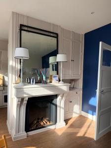 un salon avec une cheminée et un miroir dans l'établissement Charmant appartement en centre-ville, à Le Touquet-Paris-Plage
