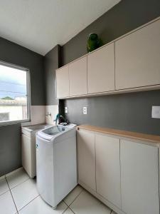 a kitchen with a washing machine and a sink at Apartment COP30 in Ananindeua
