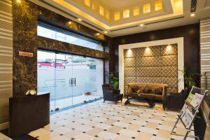 a lobby with a large glass door with a couch at The Manor Bareilly by Leisure Hotels in Bareilly