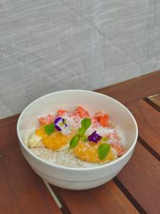 a bowl of oatmeal with fruit and flowers on it at FAM Hotel in Unawatuna