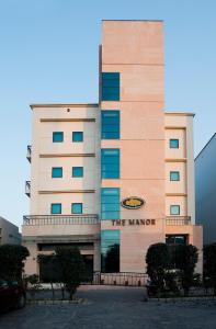 un edificio con un cartel en la parte delantera en The Manor Bareilly by Leisure Hotels, en Bareilly