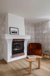 - un salon avec une cheminée, une chaise et une table dans l'établissement Maison Carola Sous Les Étoiles, à Aoste