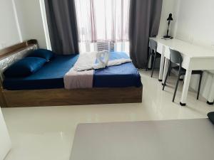 a bedroom with a bed with a desk and a white table at Dagupan Condo Stay in Dagupan