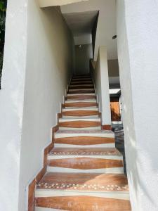 德瓦尔卡Ashtha Bungalow的楼梯通往铺有木地板的房屋 更多1张照片