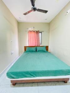 德瓦尔卡Ashtha Bungalow的一间卧室配有一张大床和吊扇