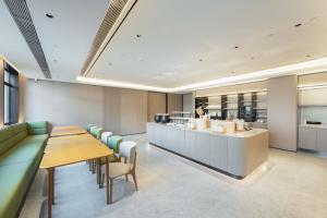 a restaurant with a long table and chairs and a counter at JI Hotel Beijing Fangzhuang Puhuangyu Subway Station in Beijing
