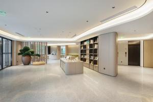a large lobby with a potted plant in a building at JI Hotel Beijing Fangzhuang Puhuangyu Subway Station in Beijing