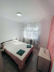 een slaapkamer met een bed met twee groene handdoeken erop bij Oty Residence Iasi in Iaşi