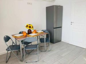 een keuken met een tafel met stoelen en een koelkast bij Oty Residence Iasi in Iaşi +12 foto's