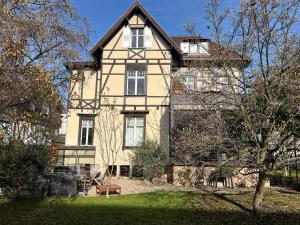 a large white house with a tree in front of it at Strasbourg Tivoli in Strasbourg