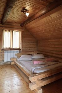 a bed in a wooden room in a log cabin at Котедж Арніка з Чаном in Vorokhta